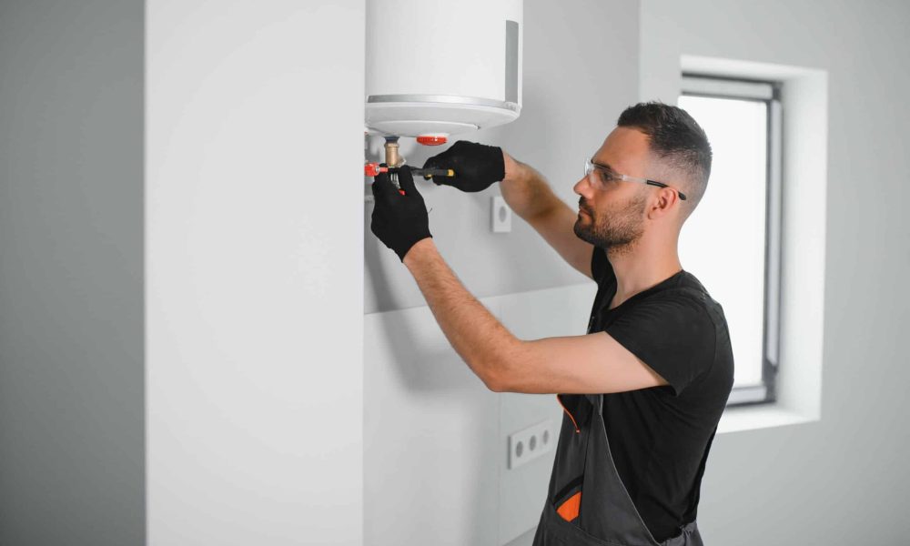 Professional plumber checking a boiler and pipes, boiler service concept.